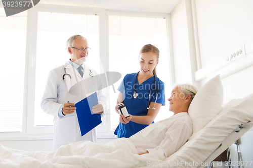 Image of doctor giving medicine to senior woman at hospital