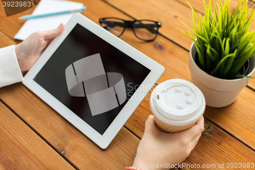 Image of close up of woman with tablet pc on wooden table