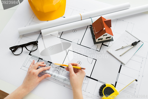 Image of close up of hands with ruler measuring blueprint