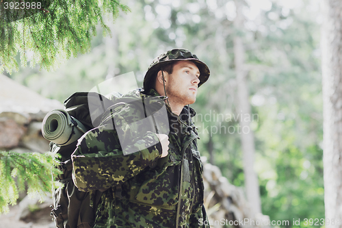 Image of young soldier with backpack in forest