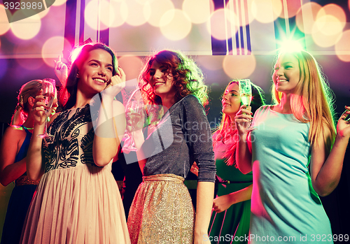 Image of smiling friends with glasses of champagne in club