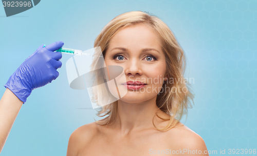 Image of happy woman face and beautician hand with syringe