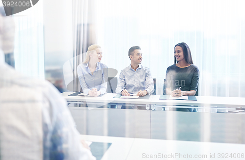 Image of group of smiling businesspeople meeting in office
