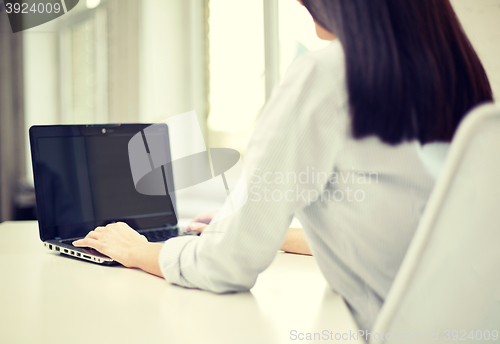 Image of close up of woman typing on laptop at office