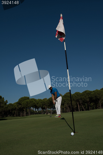 Image of golf player hitting shot at sunny day