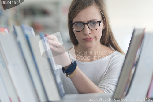 Image of portrait of famale student selecting book to read in library