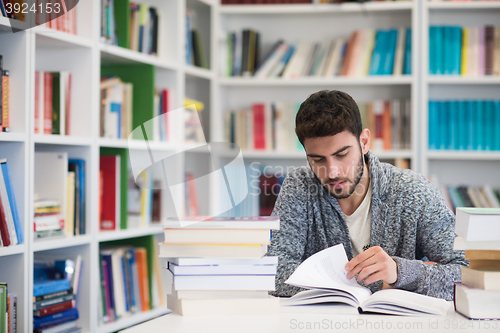 Image of portrait of student while reading book  in school library