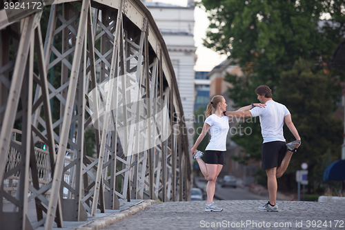 Image of couple warming up and stretching before jogging