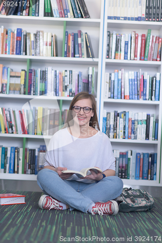 Image of famale student reading book in library