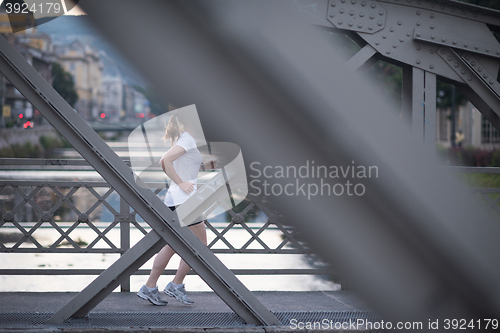 Image of sporty woman running  on sidewalk