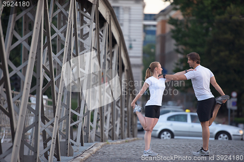 Image of couple warming up and stretching before jogging