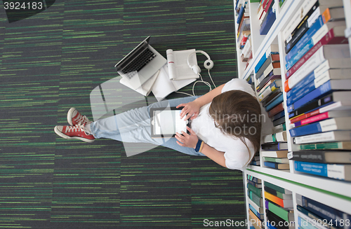 Image of female student study in library, using tablet and searching for 