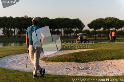 Image of golfer from back at course looking to hole in distance