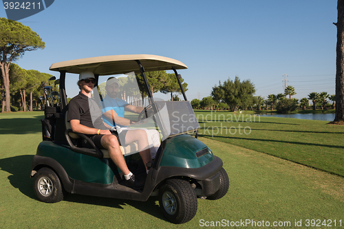 Image of golf players driving cart at course