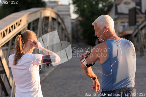 Image of jogging couple planning running route  and setting music