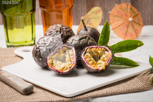 Image of Passion fruits on white ceramic tray on wooden table background.