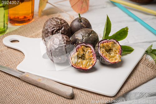 Image of Passion fruits on white ceramic tray on wooden table background.