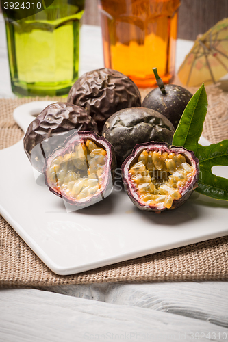 Image of Passion fruits on white ceramic tray on wooden table background.