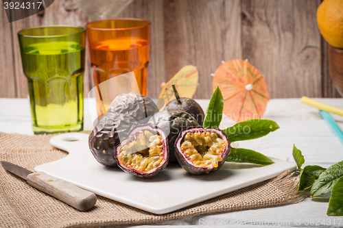 Image of Passion fruits on white ceramic tray on wooden table background.