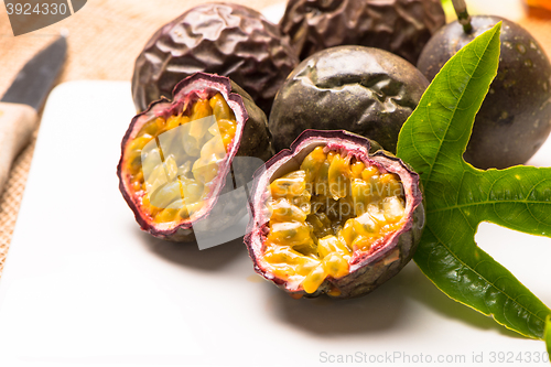 Image of Passion fruits on white ceramic tray on wooden table background.
