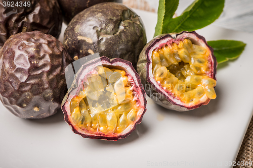 Image of Passion fruits on white ceramic tray on wooden table background.