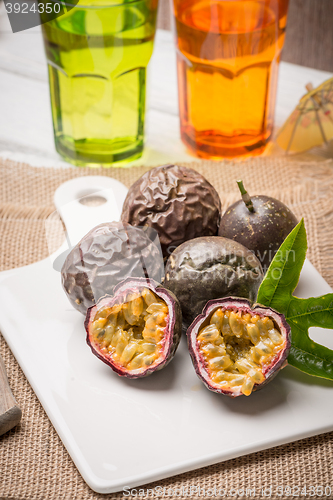 Image of Passion fruits on white ceramic tray on wooden table background.