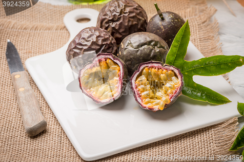 Image of Passion fruits on white ceramic tray on wooden table background.