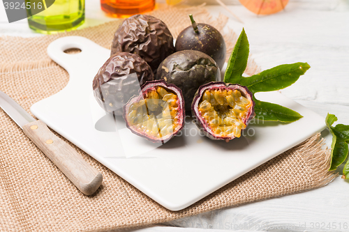 Image of Passion fruits on white ceramic tray on wooden table background.