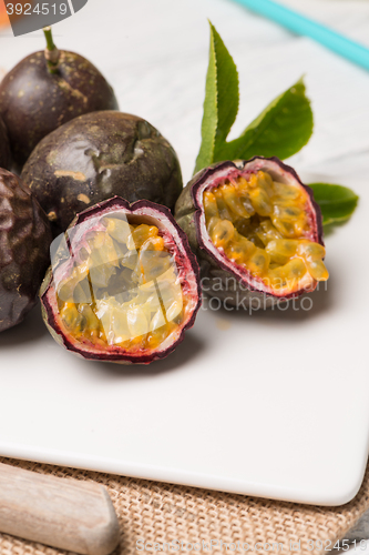 Image of Passion fruits on white ceramic tray on wooden table background.