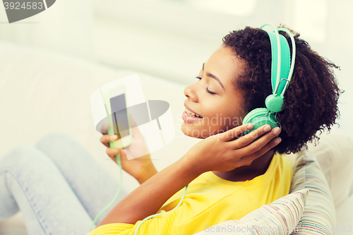 Image of happy african woman with smartphone and headphones