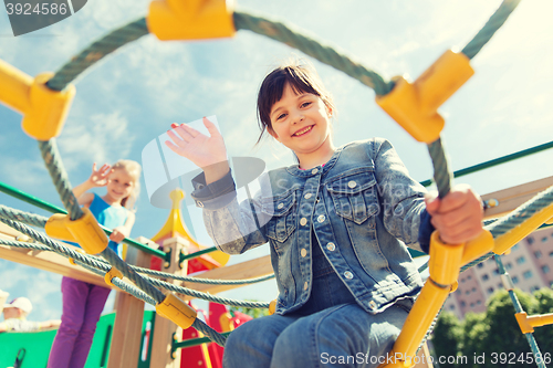 Image of happy little girl climbing on children playground