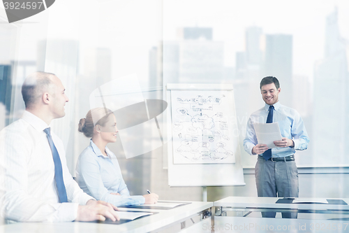 Image of group of smiling businesspeople meeting in office