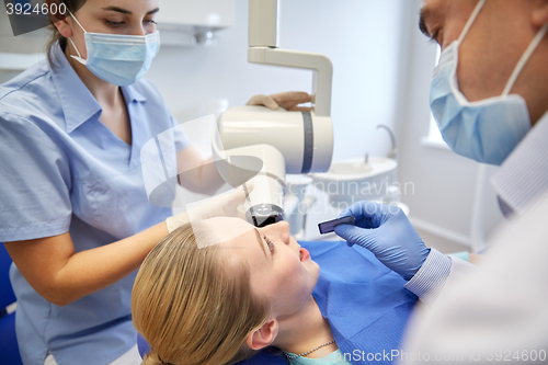 Image of dentists and patient with dental x-ray machine