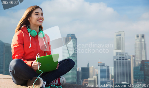 Image of happy young woman with tablet pc and headphones