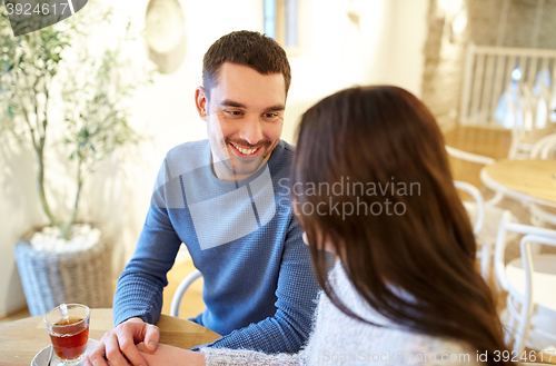 Image of happy couple drinking tea at cafe