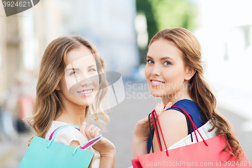 Image of happy women with shopping bags walking in city 