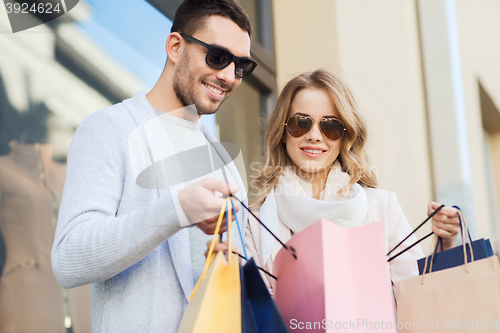 Image of happy couple with shopping bags on city street