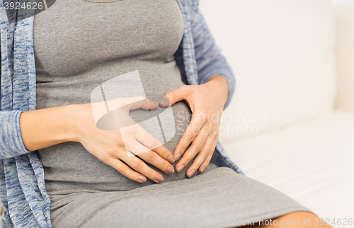 Image of close up of pregnant woman belly and heart shape