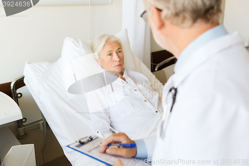 Image of senior woman and doctor with clipboard at hospital