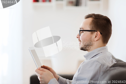 Image of smiling man working with tablet pc at home