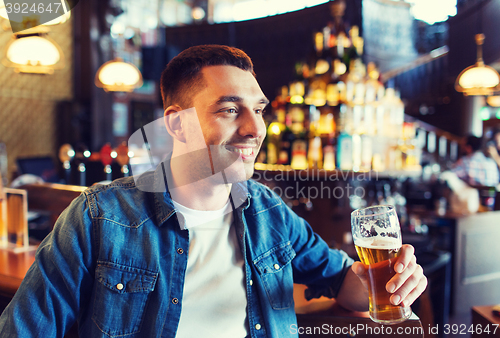 Image of happy man drinking beer at bar or pub