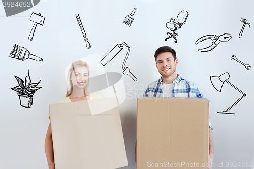 Image of smiling couple with big boxes moving to new home