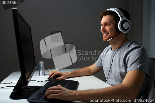 Image of man in headset playing computer video game at home