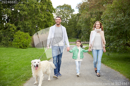 Image of happy family with labrador retriever dog in park