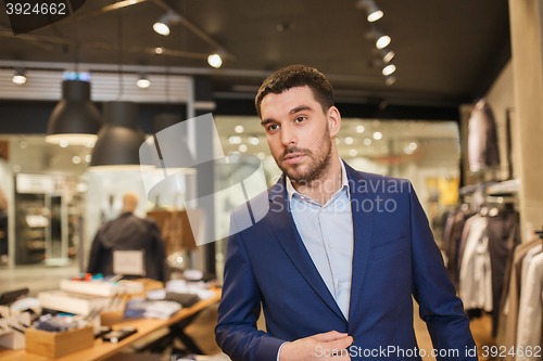 Image of young handsome man in jacket at clothing store