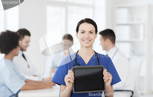 Image of happy doctor over group of medics at hospital