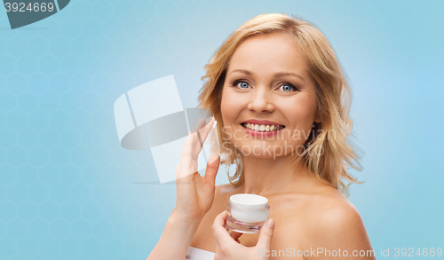 Image of happy woman applying cream to her face