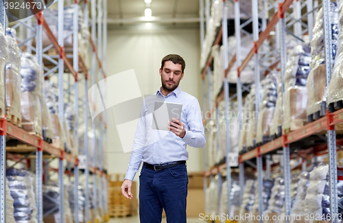 Image of businessman with tablet pc at warehouse