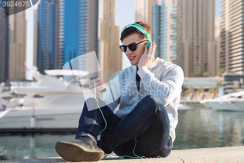 Image of happy young man in headphones with smartphone