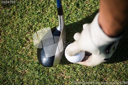 Image of golf club and ball in grass